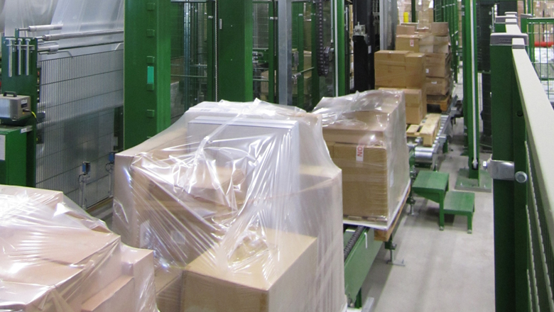 [Translate to Czech:]  MSK Stretch Hood - Automated pallet handling through free pallet feet  Special MSK technique - hood stretcher as an efficient alternative to wrap stretching  Compared to the stretch wrapping process, the stretch hood process optimizes the pallet packaging in the areas of film consumption and load stability.